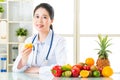 Young asian nutritionist drinking orange juice and smiling Royalty Free Stock Photo