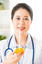 Young asian nutritionist drinking orange juice and smiling Royalty Free Stock Photo