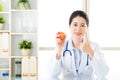 Young asian nutritionist recommend eating apple and thumbs up Royalty Free Stock Photo