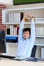 Young asian office man stretching body for relaxing while working with computer at his desk, office lifestyle, business situation Royalty Free Stock Photo