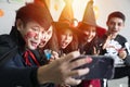 Young Asian people, a group of five persons, in scary costumes selfie their own photo. Group of friends having fun at a party