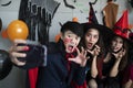 Young Asian people, a group of three persons, in scary costumes selfie their own photo. Group of friends having fun at a party