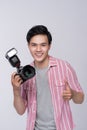 Young asian photographer holding digital camera, while working i Royalty Free Stock Photo