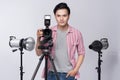 Young asian photographer holding digital camera, while working i Royalty Free Stock Photo