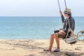 Young Asian photographer man on swing at the beach Royalty Free Stock Photo