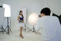 Young asian photographer is photographing a model posing in the studio Royalty Free Stock Photo