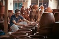 young asian pottery craftsman holding pottery products ready for sale