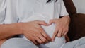 Young Asian Pregnant couple making heart sign holding belly. Mom and Dad feeling happy smiling peaceful while take care baby, Royalty Free Stock Photo