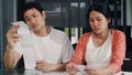 Young Asian Pregnant couple records of income and expenses at home. Dad worried, serious, stress while record budget, tax, Royalty Free Stock Photo