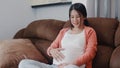 Young Asian Pregnant woman holding her belly talking with her child. Royalty Free Stock Photo