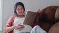 Young Asian Pregnant woman read a book for baby in belly. Mom feeling happy smiling positive and peaceful while take care child Royalty Free Stock Photo