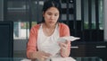 Young Asian Pregnant woman records of income and expenses at home. Mom worried, serious, stress while record budget, tax, Royalty Free Stock Photo