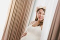 Young Asian pregnant woman standing near window at home. Royalty Free Stock Photo