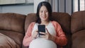 Young Asian Pregnant woman using mobile phone search pregnancy information. Royalty Free Stock Photo