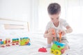 Young boy playing toys on bed Royalty Free Stock Photo