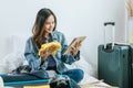 Young asian pretty hipster woman traveler prepare and packing clothes into suitcase Royalty Free Stock Photo