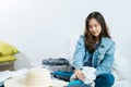 Young asian pretty woman traveler hipster prepare and packing clothes into suitcase for holiday vacation Royalty Free Stock Photo