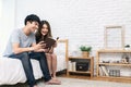 Young asian romantic couple reading book having great time together feeling satisfaction and positive in white bedroom