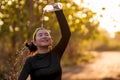 Young Asian runner girl refreshing drinking and pouring water on her head. Attractive and happy Chinese woman tired after running Royalty Free Stock Photo