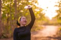 Young Asian runner girl refreshing drinking and pouring water on her head. Attractive and happy Korean woman tired after running Royalty Free Stock Photo