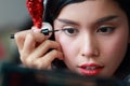 Young asian santa girl applying eye shadow on beautiful face Royalty Free Stock Photo