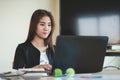 Young Asian secretary female working with laptop