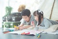 Siblings lying on the floor and drawing picture by crayon Royalty Free Stock Photo