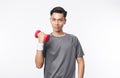 Young Asian sport man in grey t-shirt and white wristband doing exercise with dumbbell and looking camera isolated over white Royalty Free Stock Photo