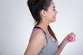 Young asian sporting woman training with dumbbell. Pretty athletic girl making physical exercise against white background. Health