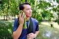 Young Asian sportman ralaxing and taking the fabric wiping sweat on the face on the face after exercise and running.