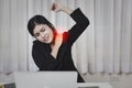 Young asian stressed businesswoman feeling pain or having problem with part of body arm shoulder or neck after working on computer Royalty Free Stock Photo