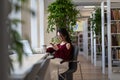 Student girl procrastinate in library with smartphone chat in social media not preparing for exam Royalty Free Stock Photo