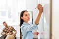 young asian student girl writing on whiteboard during lesson with blurred teacher Royalty Free Stock Photo