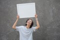 Young asian student with glasses and fedora hat standing holding white board and smiling, blank board concept