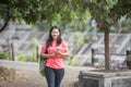 Young Asian student outdoor walking while holding her book Royalty Free Stock Photo