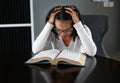 Young asian student reading a book under mental pressure