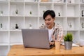 Young asian student using computer remote studying, watching online webinar, zoom virtual training on video call meeting Royalty Free Stock Photo