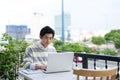 Young asian student using laptop at the city cafe shop. Royalty Free Stock Photo