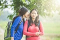 Young Asian student wishpering something to her friend Royalty Free Stock Photo