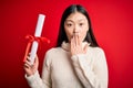 Young asian student woman holding graduate diploma over red isolated background cover mouth with hand shocked with shame for Royalty Free Stock Photo