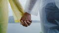 Young Asian sweet couple feeling happy using romantic time playing rain while wearing raincoat standing near lake. Lifestyle