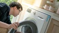 Asian technician looking into washing machine Royalty Free Stock Photo