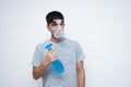 Young Asian teen boy using sanitizer while wearing oxygen mask Royalty Free Stock Photo