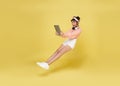 Young asian teenage girl hand holding computer laptop floating in mid-air isolated on yellow background. Fast internet concept Royalty Free Stock Photo