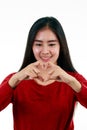 Young Asian teenager making heart symbol shape from her hands on white background Royalty Free Stock Photo