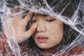 Young asian thai black short hair woman wrap in plastic cellophane