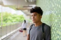 Young Asian tourist man as backpacker thinking at the footbridge