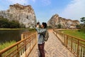 Young Asian tourist taking a picture of rocky mountain of khao Ngu Stone Park , Ratchaburi , Thailand. Royalty Free Stock Photo