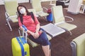 Young Asian tourist woman with mask sitting with distance at the airport