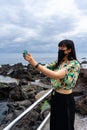 Young Asian tourist woman taking a photo with her smartphone. Royalty Free Stock Photo